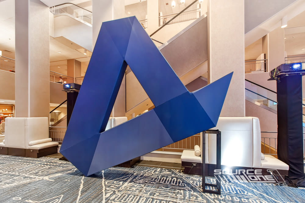 Oversized three-dimensional THRIVE logo displayed in a conference venue.