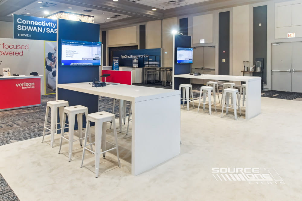 Modern technology exhibit with blue branding, product demonstrations, and collaborative meeting environment.