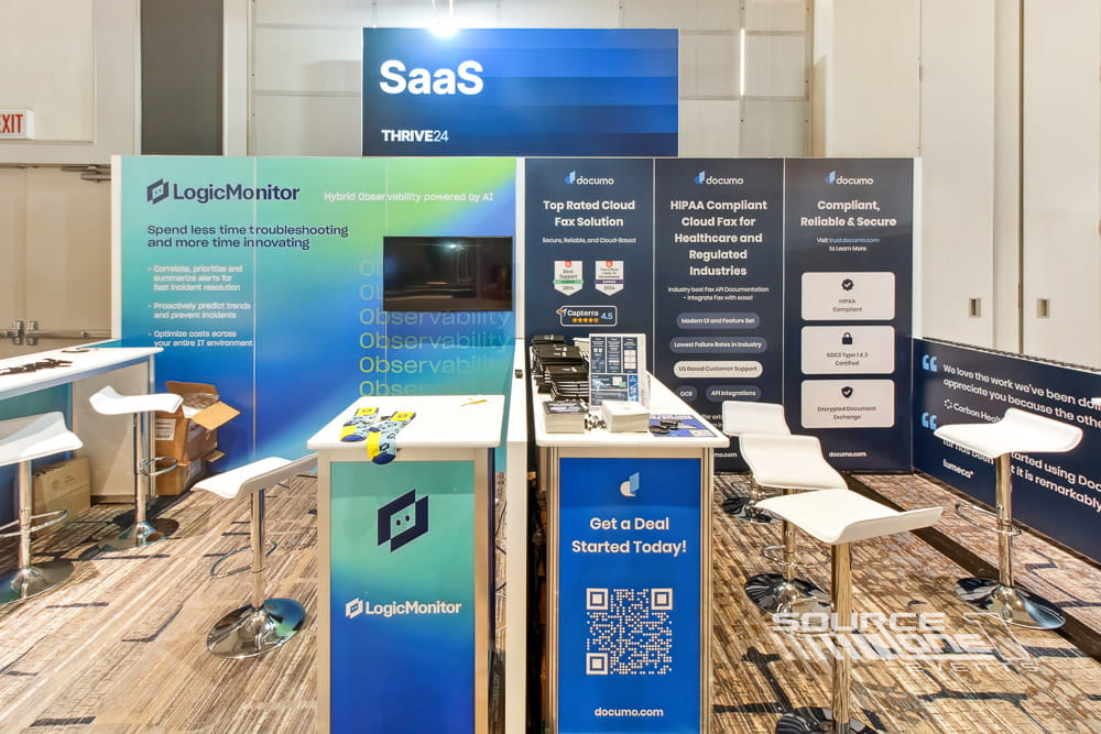 SaaS technology exhibit with illuminated graphics, product messaging, touchscreen displays, and modern booth construction.