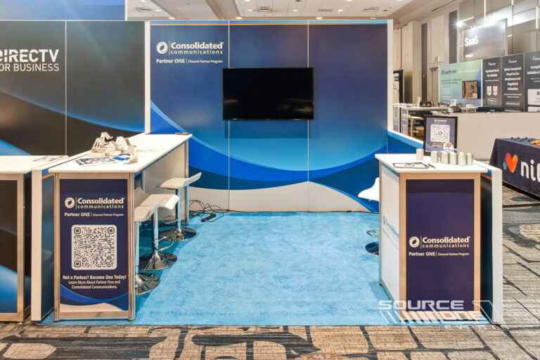 Contemporary trade show booth with large LED monitor, blue graphic walls, and clean modular exhibit design.