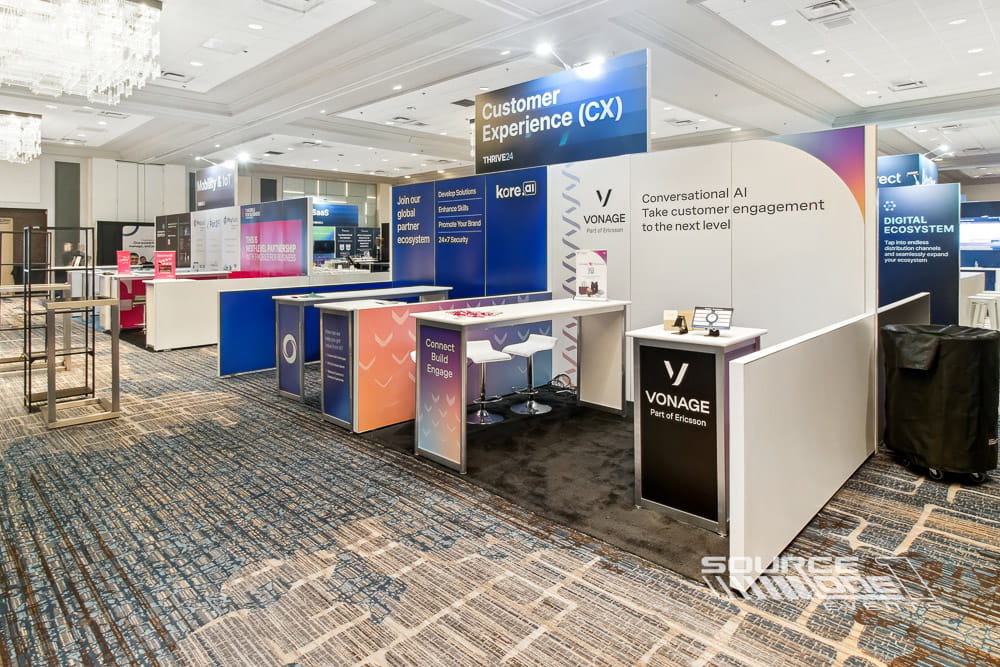 Open hardwall exhibit with colorful product graphics, interactive displays, and collaborative meeting spaces.