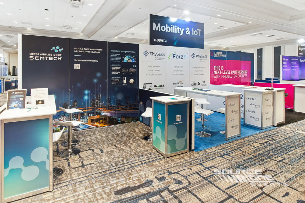 Large technology exhibit with digital product walls, blue corporate graphics, and custom architectural displays.
