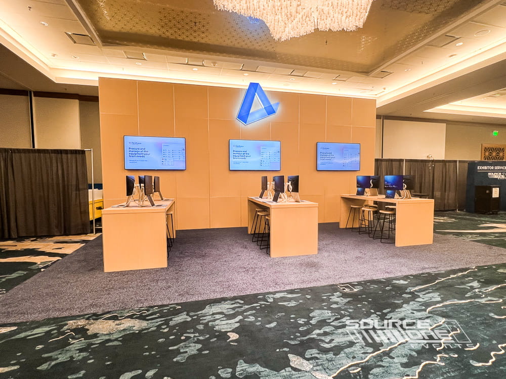 Custom AppDirect exhibit featuring branded meeting counters, digital displays, and open attendee engagement space.