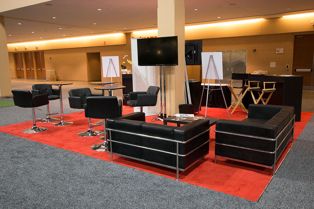 Trade show presentation stage with lounge seating and audiovisual production