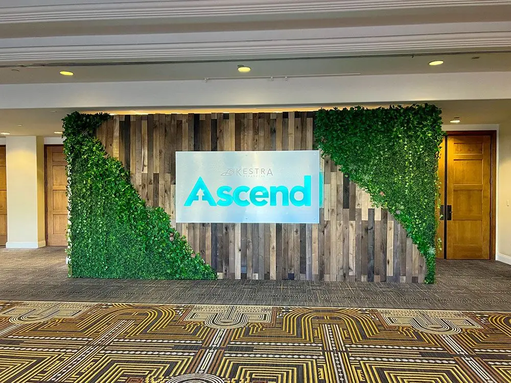 Custom Ascend event entrance with illuminated branding and natural wood accent walls.